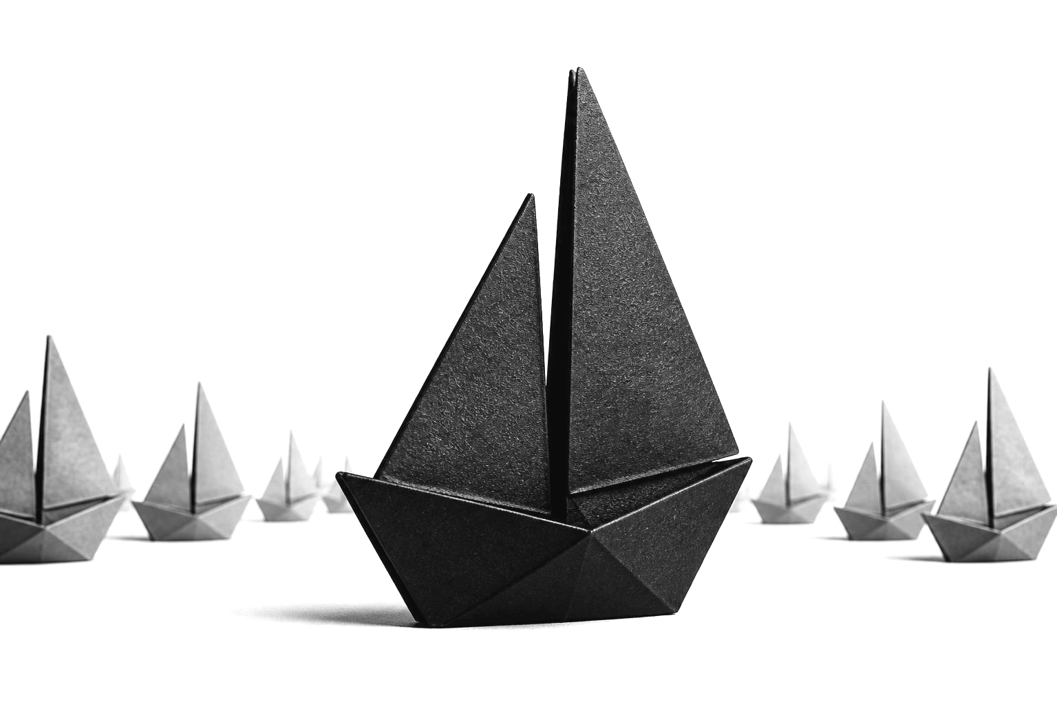 A large origami sailboat leading a fleet of smaller boats